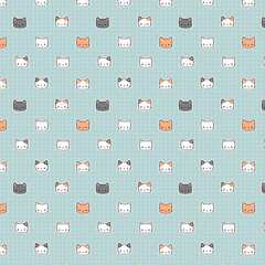 Cute seamless pattern of cartoon cat faces in soft colors on a blue grid background, perfect for fabric, stationery, or wallpaper.