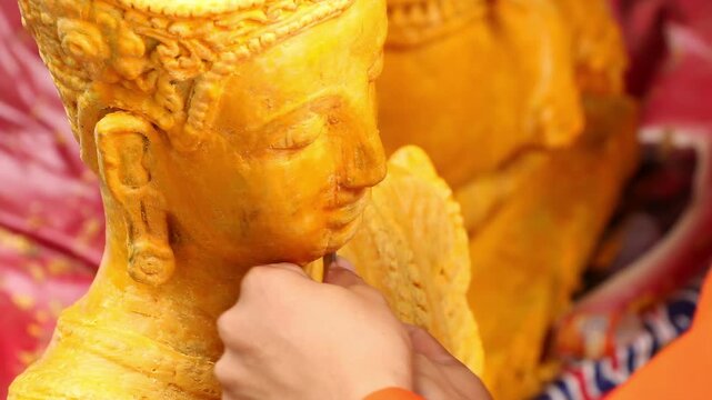 Hand carving a giant Buddhist Lent candle float sculpture in Chiang Rai Thailand.