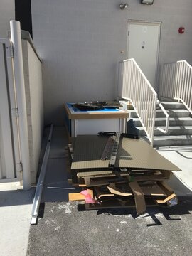 Bunch of Junk Piled Up Outside of Building by Stairs 