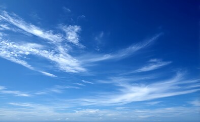 Obraz premium A serene blue sky with minimal clouds, creating an atmosphere of tranquility and freedom