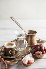 Cup of coffee and glass of water and dry dates on saucer ready to eat for iftar time. Islamic religion and ramadan concept.