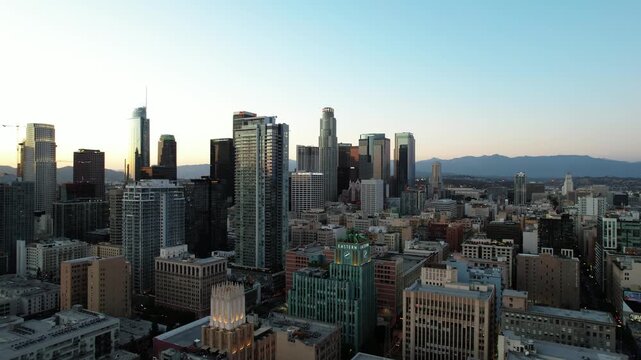 Cinematic aerial view of downtown Los Angeles right before sunset, vast cityscape of skyline and tall skyscrapers 