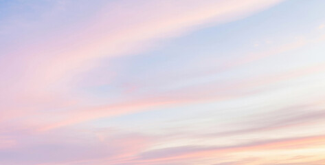 Soft pastel colored sky with clouds in shades of pink, purple, and blue glowing beautifully during twilight, creating a dreamy and artistic color harmony.