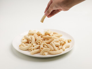 Crunchy macaroni snacks, piled on white background