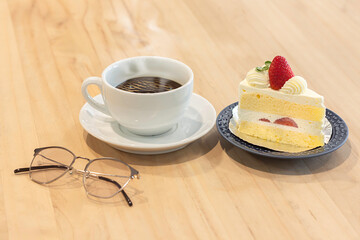 Enjoying coffee and strawberry cake at a cozy cafe in the afternoon