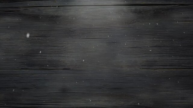Snow falling gently over dark wooden boards creating a serene winter atmosphere background