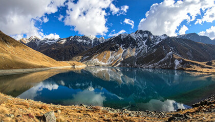 Stunning Mountain Lake Reflection Under Blue Sky with Clouds.