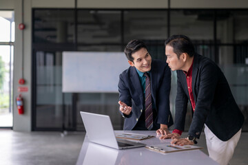 Businessmen discussing work using laptop in modern office