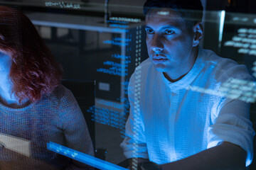 Professional IT Technical Support Specialist or Software Developer pointing and analyzing code in control room of computers.