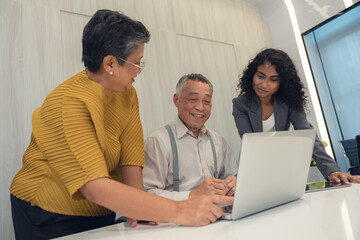 Senior consultant client over agent, broker discussing home sale, medical insurance terms, trust fund investments, meeting at laptop in office.