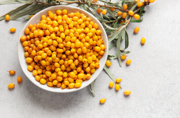 Sea buckthorn berries in bowl with branches