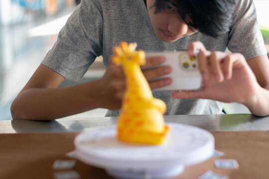 Close-up shot of a young man intensely focusing on his smartphone screen while using it to capture images for 3D photogrammetry scanning.