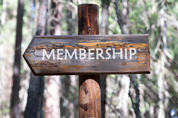 MEMBERSHIP text written on a wooden signpost against a forest background. Human resources recruitment concept