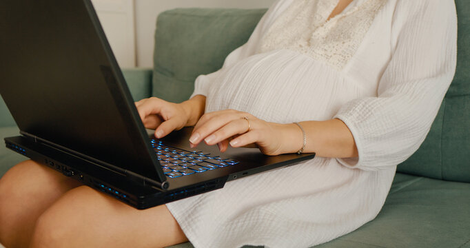 Side view of woman hands typing on laptop hustling while pregnant. Business pregnant woman works from home. Freelance and remote work. - Powered by Adobe
