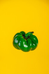 Red,yellow and green sweet peppers on yellow background