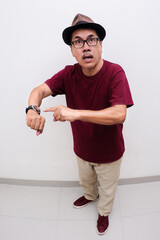 Closeup shot of a man looking impatient by pointing finger at the wrist watch