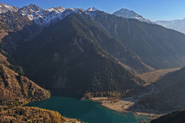 Obraz premium Lake Issyk in the rays of the setting sun. National Nature Park. Mountainous area with different vegetation. View from a drone.