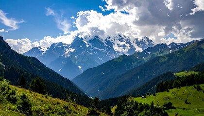 Fototapeta premium Scenic view of a majestic snow-capped mountain range under a blue sky with fluffy white clouds and green valleys