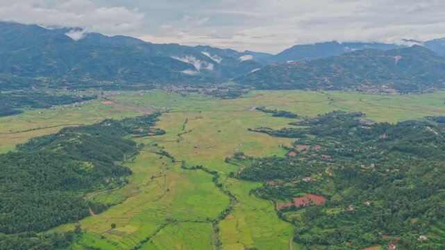 Aerial view of lush green paddy fields in Tansen Palpa, Nepal, surrounded by beautiful mountains and rural landscapes, showcasing the region&rsquo;s rich agriculture and natural beauty.