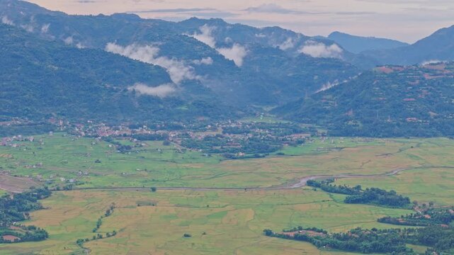 Aerial view of lush green paddy fields in Tansen Palpa, Nepal, surrounded by beautiful mountains and rural landscapes, showcasing the region&rsquo;s rich agriculture and natural beauty.