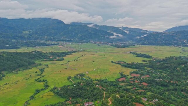 Aerial view of lush green paddy fields in Tansen Palpa, Nepal, surrounded by beautiful mountains and rural landscapes, showcasing the region&rsquo;s rich agriculture and natural beauty.