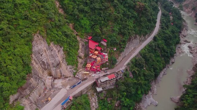 Aerial drone footage of the famous Siddhababa Temple in Tansen Palpa, Nepal, located on a scenic hillside with winding mountain roads and stunning natural surroundings.