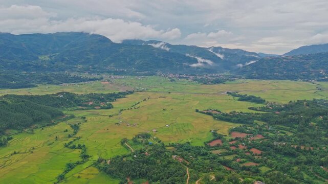 Aerial view of lush green paddy fields in Tansen Palpa, Nepal, surrounded by beautiful mountains and rural landscapes, showcasing the region&rsquo;s rich agriculture and natural beauty.