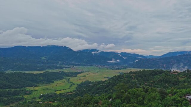 Aerial view of lush green paddy fields in Tansen Palpa, Nepal, surrounded by beautiful mountains and rural landscapes, showcasing the region&rsquo;s rich agriculture and natural beauty.