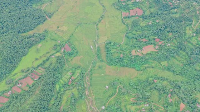 Aerial view of lush green paddy fields in Tansen Palpa, Nepal, surrounded by beautiful mountains and rural landscapes, showcasing the region&rsquo;s rich agriculture and natural beauty.