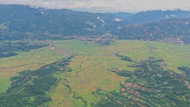 Aerial view of lush green paddy fields in Tansen Palpa, Nepal, surrounded by beautiful mountains and rural landscapes, showcasing the region&rsquo;s rich agriculture and natural beauty.