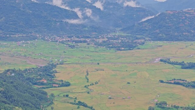 Aerial view of lush green paddy fields in Tansen Palpa, Nepal, surrounded by beautiful mountains and rural landscapes, showcasing the region&rsquo;s rich agriculture and natural beauty.