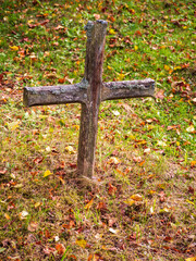 A wooden cross in a quiet cemetery symbolizes the transience of life, remembrance of the dead, and hope for eternity where the soul meets God.