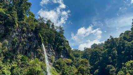 Tropical waterfall surrounded by green cliffs
