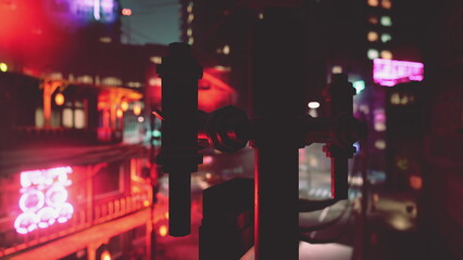 A bustling cityscape at night glimmers with neon signs and colorful lights. The urban environment creates a lively atmosphere, showcasing nightlife activities and excitement.