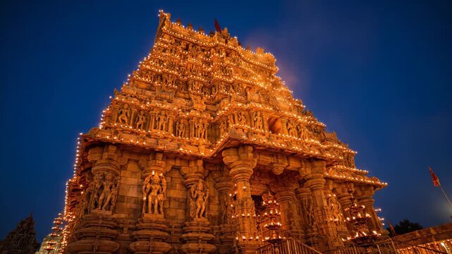 Magnificent ancient hindu temple illuminated with countless traditional oil lamps under a vibrant night sky during karthigai deepam festival in india