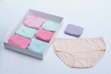 Set of colorful women’s cotton underwear in pastel tones neatly folded in a white box with one pair displayed. Soft fabric, clean background, perfect for fashion, hygiene, and lifestyle concepts.