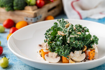 Fresh kale salad with mushrooms, roasted squash, and crunchy nuts