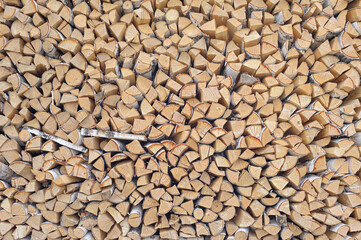 Neatly stacked firewood filling the entire frame, uniform logs arranged in rows, rustic texture, outdoor setting, natural wood pattern