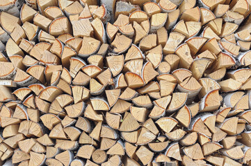Neatly stacked firewood filling the entire frame, uniform logs arranged in rows, rustic texture, outdoor setting, natural wood pattern