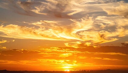 Dramatic Sunset Sky with Wispy Clouds Over Distant Cityscape Warm Golden Hour Light Creates Fiery Orange and Yellow Hues