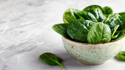 Obraz premium Fresh spinach leaves in a rustic ceramic bowl, healthy eating concept, bright and clean aesthetic.