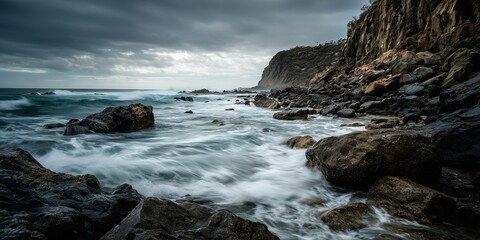Time lapse of waves crashing on rocky shoreline, water movement blurred, sharp rocks and cliff in foreground, dramatic natural scene.