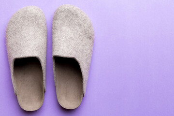 Warm winter women woolen slippers on colored background. Copy space for text