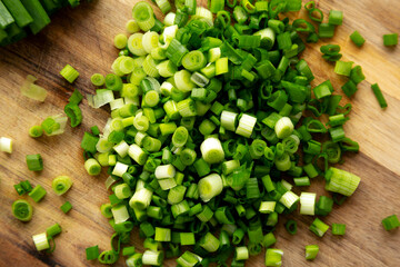 Organic Green Chopped Chives on a Wooden Board, top view.