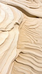 Close-up of layered, pale beige rock formations, exhibiting swirling, rhythmic patterns