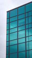 Modern office building facade with teal-colored glass panels