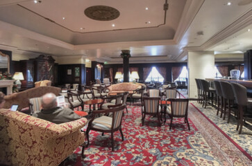 Elegant interior design furnishing bar lounge area onboard cruiseship cruise ship liner in Art Deco design with chairs, tables, bar counter and room dividers