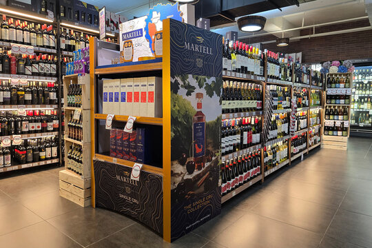 Penang, Malaysia &ndash; Sep 26, 2025: A premium Martell Single Cru cognac promotional display surrounded by a wide selection of imported wines inside Mercato grocery store.