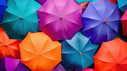 A vibrant collection of umbrellas in various colors including purple, blue, orange, and teal. The umbrellas are arranged closely together, creating a colorful pattern.