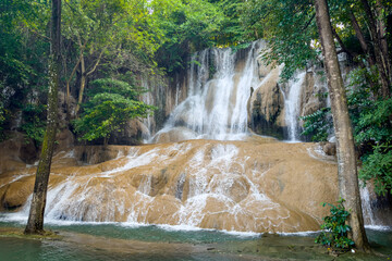 Sai Yok Noi Waterfall in Kanchanaburi, Thailand, is a charming spot surrounded by lush forest, a gentle cascade, peaceful nature, and beautiful scenery.